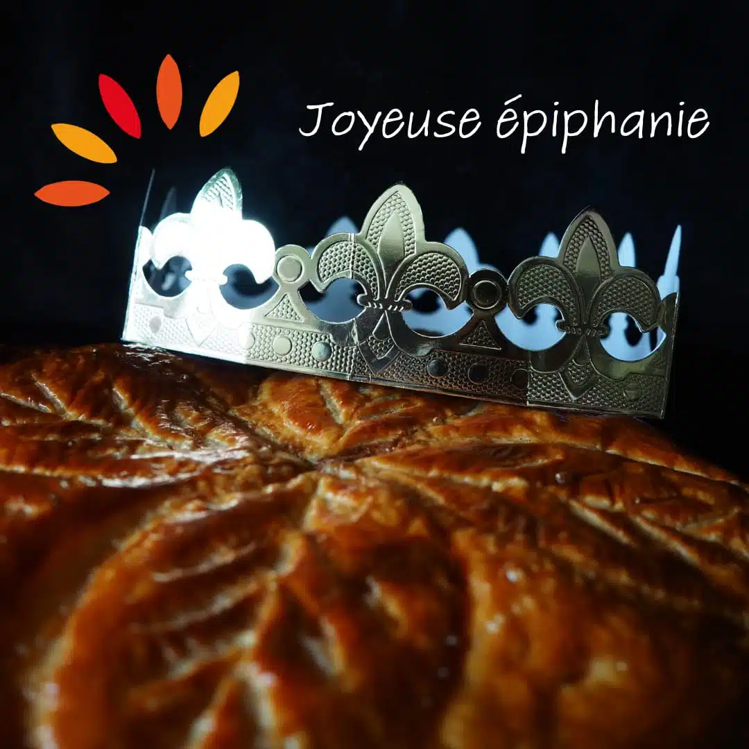 Une couronne dorée repose sur une galette des rois, mettant en valeur ses motifs fleuris et sa pâte dorée. En arrière-plan, l'inscription 'Joyeuse Épiphanie' accompagne un motif coloré évoquant la fête.