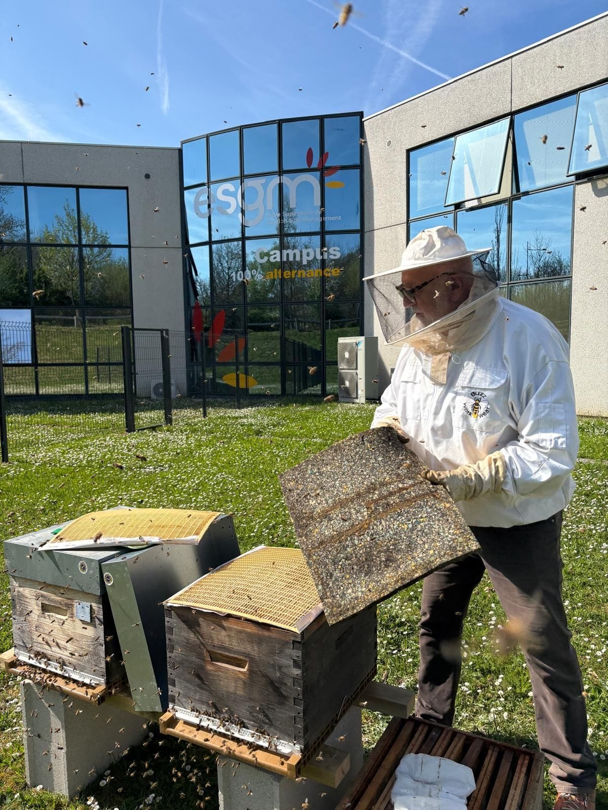 Serge Schueller, producteur passionné entrain d'ouvrir une des deux ruche dans le jardin de l'Esgm & Proformat - Pigier Mulhouse